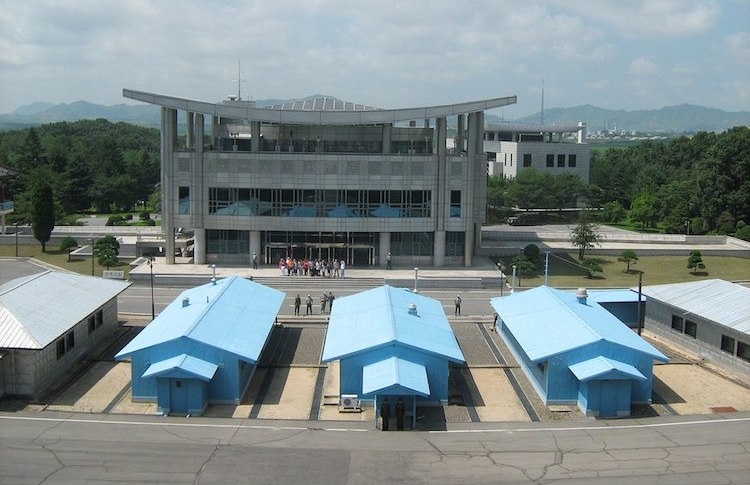Photo: The Conference Row in the Joint Security Area of the Korean Demilitarized Zone, looking into South Korea from North Korea. It shows guards on both sides and a group of tourists in the South. Created: 26 July 2012. Credit: Wikimedia Commons.